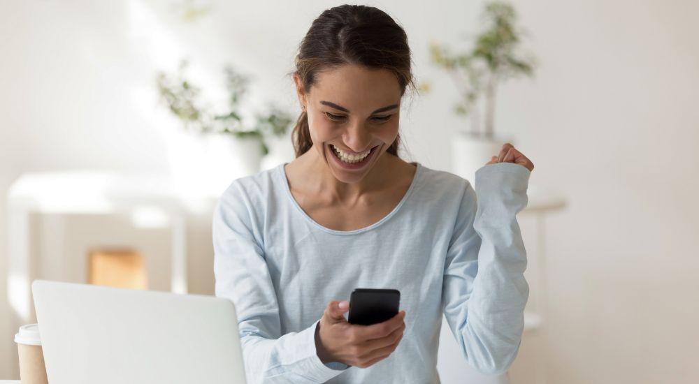 woman looking at phone, happy