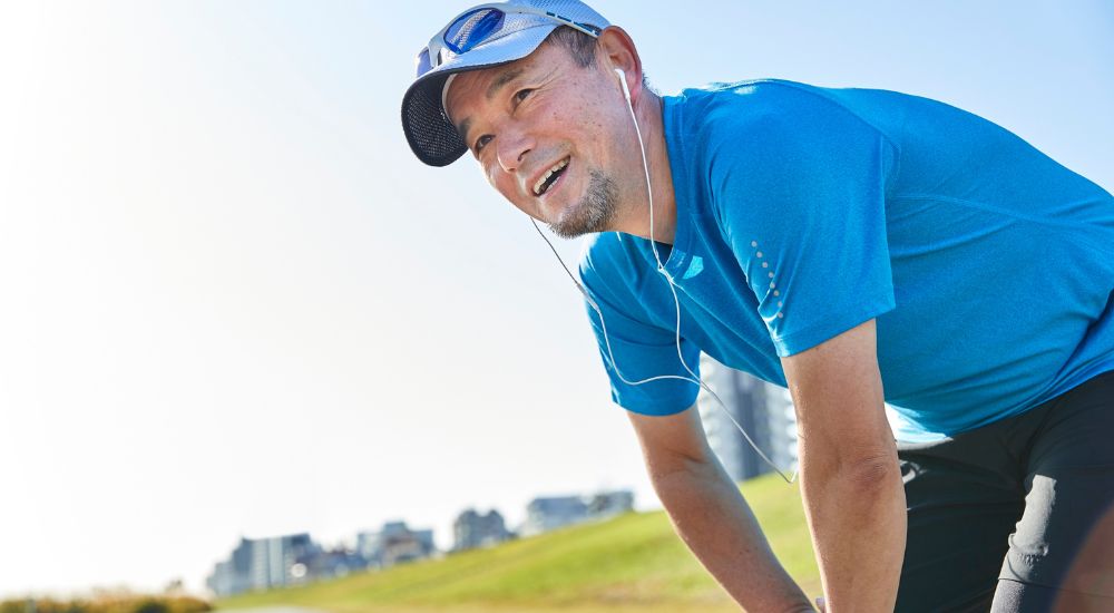 Man smiling and taking a break outdoors, symbolizing relaxation, wellness, and mental health.
